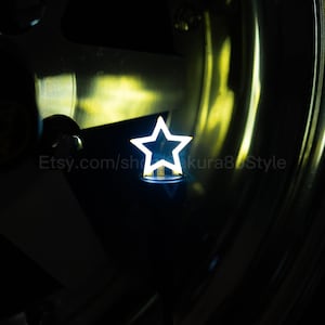 May include: A bright white star-shaped light. The star is illuminated with a bright white light, set against a dark background. The Etsy shop name is visible in the image.