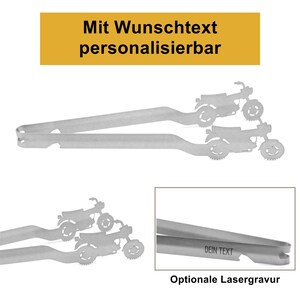 Könnte beinhalten: Eine silberfarbene Metall-Küchenzange mit Motorrad-Motiv an den Greifenden. Über der Zange steht "Mit Wunschtext personalisierbar", und ein Detailausschnitt zeigt die Gravur "DEIN TEXT" auf dem Griff der Küchenzange.