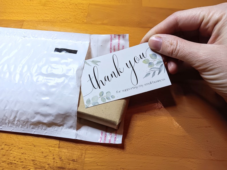 May include: A white thank you card with green leaves and the text "thank you for supporting my small business".