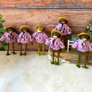 Sapo de crochê em amigurumi: brinquedo artesanal em algodão orgânico com suéter roxo de abelha.
