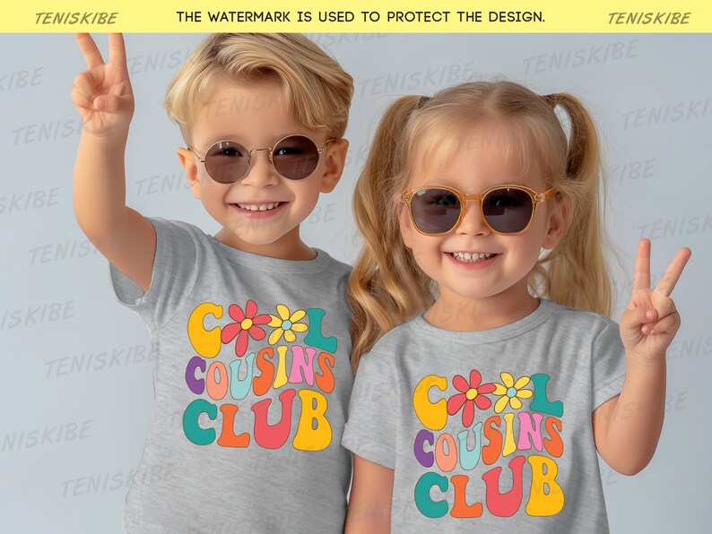 K&ouml;nnte beinhalten: Zwei Kinder tragen graue T-Shirts mit dem Text "Cool Cousins Club" in bunter Retro-Schrift. Die Kinder tragen Sonnenbrillen und l&auml;cheln.