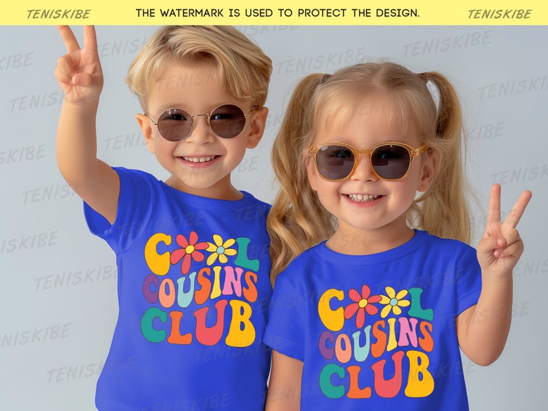 K&ouml;nnte beinhalten: Zwei Kinder tragen blaue T-Shirts mit dem Text "Cool Cousins Club" in bunter Retro-Schrift und Blumen. Die Kinder tragen Sonnenbrillen und l&auml;cheln.