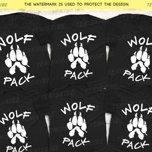 May include: Five black t-shirts with a white wolf paw print and the text "Wolf Pack" printed on the front.