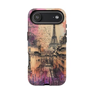 May include: A phone case featuring a Parisian street scene with the Eiffel Tower, buildings, and lavender flowers. The design includes script and watercolor-style accents in shades of pink, orange, and purple.
