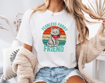 May include: White t-shirt with a retro-style graphic of a cat wearing a red bandana. The graphic says "Fearless Furry Friend".