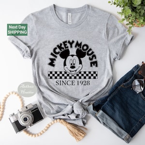 a mickey mouse shirt with a camera next to it