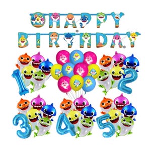 May include: A birthday party decoration set featuring a blue banner with the text HAPPY BIRTHDAY, numerous colourful latex balloons with shark illustrations, and blue foil number balloons representing the digits one through five.