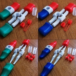 Può includere: Assortimento di chiusure a scatto in plastica colorate con accenti bianchi, rossi, blu e verdi. Le chiusure sono smontate e disposte su una superficie di legno.