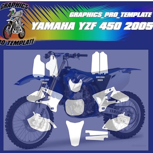 Könnte beinhalten: Ein weiß-blaues Yamaha YZF 450 2005 Dirtbike mit einer Grafik-Kit-Vorlage. Die Vorlage enthält Grafiken für die vorderen und hinteren Kotflügel, die Gabeln, die Seitenverkleidungen, die Schwinge und die Nummernschilder.