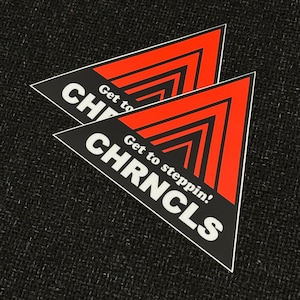 May include: Two triangular stickers with a black background and red arrow design. The stickers have the text "CHRNC LS" and "Get to steppin'!" in white.