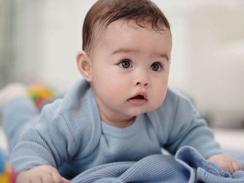 Baby in blauem Merino-Strampler von vorne