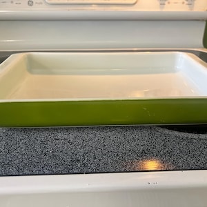 Puede incluir: Una fuente rectangular para horno con un interior blanco liso y brillante y un exterior de color verde lima vibrante. El recipiente presenta un borde ancho y plano con paredes profundas, diseñado para hornear con un acabado uniforme.