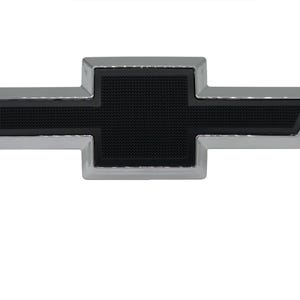Puede incluir: Un emblema de Chevrolet en forma de pajarita con una incrustación central negra texturizada rodeada por un borde de cromo pulido. La icónica forma de cruz horizontal es simétrica con bordes definidos, presentando un acabado de alto contraste en metal y negro mate.