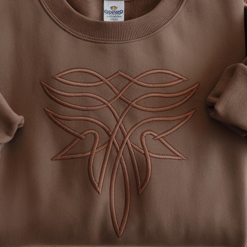 Pu&ograve; includere: Una felpa marrone con un design ricamato dettagliato in una tonalit&agrave; pi&ugrave; chiara di marrone. Il design &egrave; un motivo simmetrico intricato. La felpa ha un girocollo e maniche lunghe. Il marchio "ODPRO" &egrave; visibile sull'etichetta.