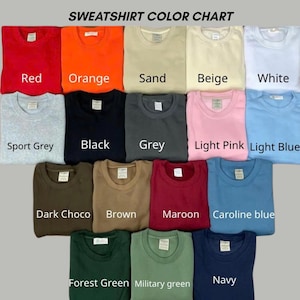 May include: A sweatshirt color chart displaying fifteen crewneck sweatshirts in various colors including red, orange, sand, beige, white, sport grey, black, grey, light pink, light blue, dark choco, brown, maroon, caroline blue, forest green, military green, and navy.