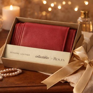 May include: A red leather wallet in a gift box with a gold ribbon. The box contains a card that reads "GENUINE LEATHER" and "collectibles by Rolfs". The wallet is a deep red color and appears to be made of high-quality leather.
