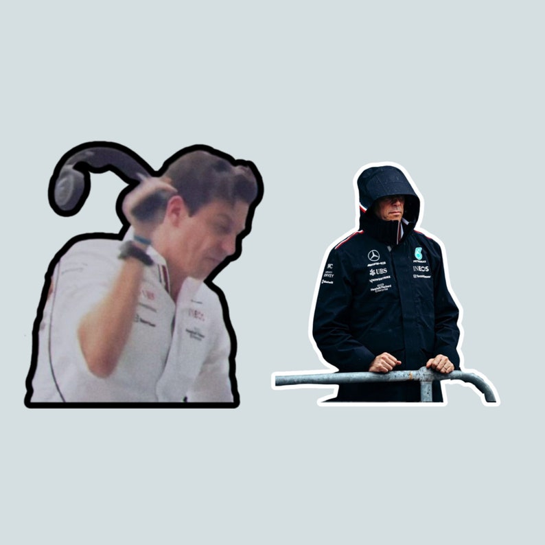 May include: Two men, one wearing a white shirt and the other wearing a black jacket with the Mercedes-AMG Petronas Formula One Team logo, stand in front of a gray background.