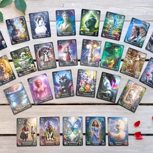 Pode incluir: Uma cole&ccedil;&atilde;o de cartas de tar&ocirc; com v&aacute;rias ilustra&ccedil;&otilde;es, incluindo figuras, animais e imagens simb&oacute;licas. As cartas est&atilde;o dispostas sobre uma superf&iacute;cie de madeira clara, com algumas cartas apresentando n&uacute;meros e t&iacute;tulos. P&eacute;talas de rosa vermelhas e uma rosa ao fundo.