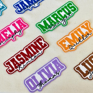 May include: A collection of colorful embroidered name patches. Each patch features a different name in a bold, stylized font, with a contrasting outline. Names include Marcus, Emily, Jasmine, and Olivia.