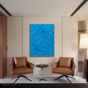 Puede incluir: Una pintura sobre lienzo rectangular vertical que presenta pinceladas de empaste gruesas y texturizadas en varios tonos de azul. Peque&ntilde;as figuras abstractas blancas y negras similares a p&aacute;jaros est&aacute;n dispersas por la superficie.