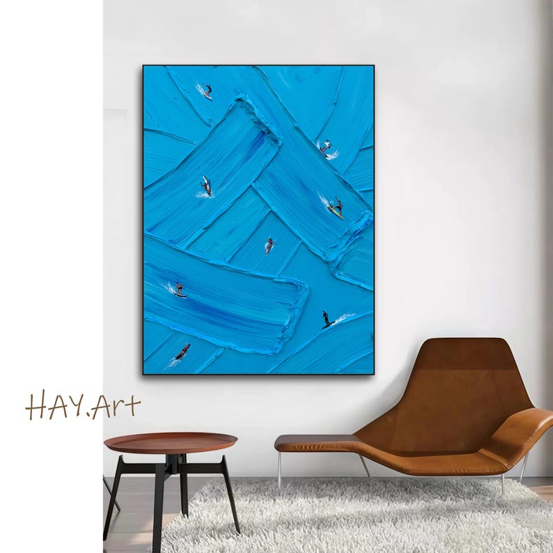 Puede incluir: Una pieza de arte mural rectangular con un fondo azul vibrante y pinceladas gruesas y texturizadas. Peque&ntilde;as figuras de surfistas sobre tablas est&aacute;n dispersas por el lienzo, creando una sensaci&oacute;n de movimiento en las olas azules abstractas.
