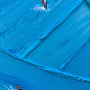 Puede incluir: Una pintura al &oacute;leo sobre lienzo con pinceladas gruesas y texturizadas en varios tonos de azul que representan olas del mar. Se muestran dos peque&ntilde;as figuras surfeando en el agua, una sobre una tabla de surf y otra sobre una tabla de windsurf.