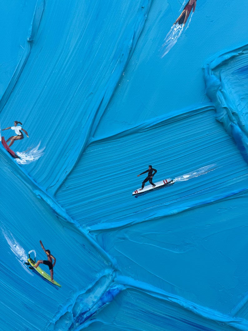 Op de afbeelding: Een olieverfschilderij met dikke, getextureerde blauwe impasto-penseelstreken die oceaangolven voorstellen. Vier kleine figuren surfen op kleurrijke planken over het oppervlak, wat witte waterspatten en bewegingssporen in de verf cre&euml;ert.