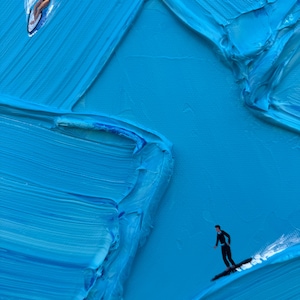 Puede incluir: Una pintura al &oacute;leo sobre lienzo con pinceladas de impasto azul gruesas y texturizadas que crean un efecto de ola. Se representan dos figuras peque&ntilde;as: una persona con una parte superior roja surfeando y otra con un traje negro sobre una tabla.
