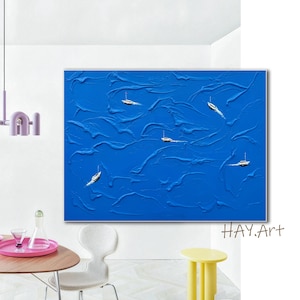 May include: A rectangular wall art piece featuring a vibrant blue textured background with thick, raised paint strokes. Four small, detailed white and black motorboats are positioned across the canvas, appearing to navigate the blue surface.