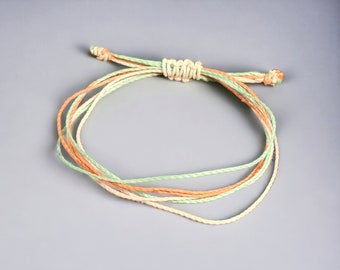 Pura Vida style 6 strand waxed cord adjustable bracelet. Teal, coral, and white