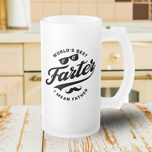 May include: A white beer stein with a large handle. The stein features the text "World's Best Farter I Mean Father" in black, with sunglasses and a mustache graphic.