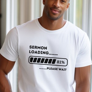 May include: White t-shirt with the text "SERMON LOADING..." above a loading bar graphic that is 81% complete. The text "...PLEASE WAIT" is below the graphic. The shirt is a crew neck style.