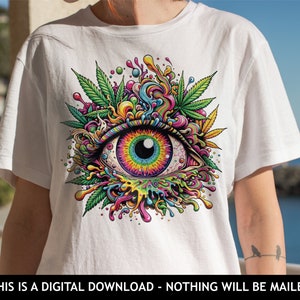 May include: A white t-shirt with a colorful psychedelic eye graphic. The eye is surrounded by green leaves and colorful swirls. The graphic is a digital illustration.