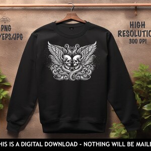 Op de afbeelding: Zwart sweatshirt met een grafische print van twee schedels met vleugels. De schedels kijken elkaar aan en zijn omringd door een bloemmotief.