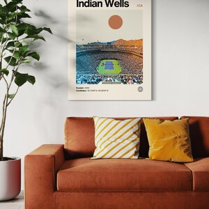 May include: A retro-style poster with a minimalist design featuring a photograph of a large stadium with a tennis court in the center. The poster is titled "Indian Wells / CA" and includes the text "Founded / 2009" and "Coordinates: 33.7205&deg;N, 116.3059&deg;W".