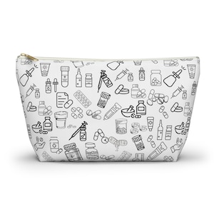 May include: White zippered pouch with a black and white doodle pattern of various medical supplies, including pills, bottles, syringes, and bandages.