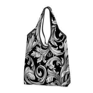 Puede incluir: Una bolsa de compras reutilizable negra con un patrón floral blanco. El patrón presenta intrincados remolinos y hojas.