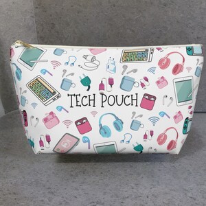May include: White zippered pouch with a colorful pattern of tech accessories, including headphones, earbuds, charging cables, and a tablet. The pouch has the text "TECH POUCH" printed on it.