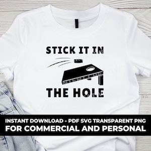 以下が含まれることがあります： 黒い文字で「STICK IT IN THE HOLE」と書かれた白いTシャツと、コーンホールボードの黒いシルエットと、それに飛んでいくビーンバッグ。Tシャツの下部には「INSTANT DOWNLOAD - PDF SVG TRANSPARENT PNG FOR COMMERCIAL AND PERSONAL」という文字が書かれている。