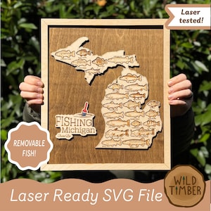 May include: A wooden wall art piece featuring a laser-cut map of Michigan with various fish species engraved on the surface. The map includes a text label that reads Fishing Michigan and a small red and white fishing bobber graphic attached.