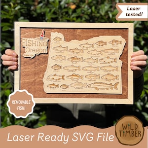 May include: A wooden wall plaque featuring a map of Oregon with laser-engraved illustrations of various fish species. The text reads Fishing Oregon Bucket List. The design includes a small fishing bobber icon and removable wooden fish cutouts.