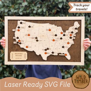 May include: Wooden map of the United States with pumpkin icons marking haunted houses. The map is framed in light wood and set against a dark wood background. Text on the map includes "HAUNTED HOUSES" and "BUCKET LIST". The image also includes the text "Track your travels!"