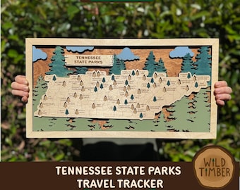 Puede incluir: Un mapa de seguimiento de viajes de los parques estatales de Tennessee en madera con un marco de madera clara. El mapa presenta detalles cortados con láser del contorno del estado, parques, árboles y nubes. El texto "Tennessee State Parks" y "Travel Tracker" es visible.