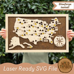 May include: A rectangular wooden wall art piece featuring a laser-cut map of the United States with Alaska and Hawaii. The map includes black and yellow warning triangle icons marking various locations, with text reading Cryptids of the United States.