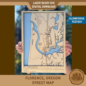 May include: A wooden street map of Florence, Oregon, with laser-cut details. The map features a light blue river and coastal areas, with the city's streets and landmarks etched into the wood. The text "FLORENCE, OREGON STREET MAP" is displayed at the bottom.