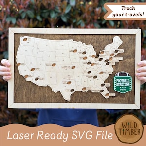 May include: Wooden map of the United States with football-shaped markers indicating stadium locations. The map is framed in light wood and mounted on a dark wood background. The text "Track your travels!" is at the top. The text "Laser Ready SVG File" is at the bottom.