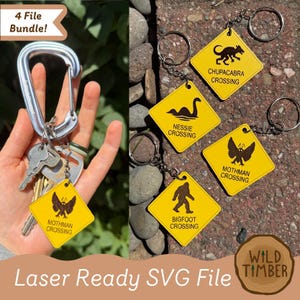 May include: A collection of yellow keychains with black graphics and text, including "Nessie Crossing," "Bigfoot Crossing," and "Mothman Crossing." The keychains are attached to silver keyrings. The image also includes a carabiner and keys.
