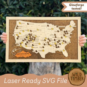 May include: A rectangular wooden wall map of the United States featuring a light wood map cutout on a dark wood background. The map includes small yellow and dark brown duck icons, text labels for trails, and an orange Jeep Overlanding Bucket List icon.