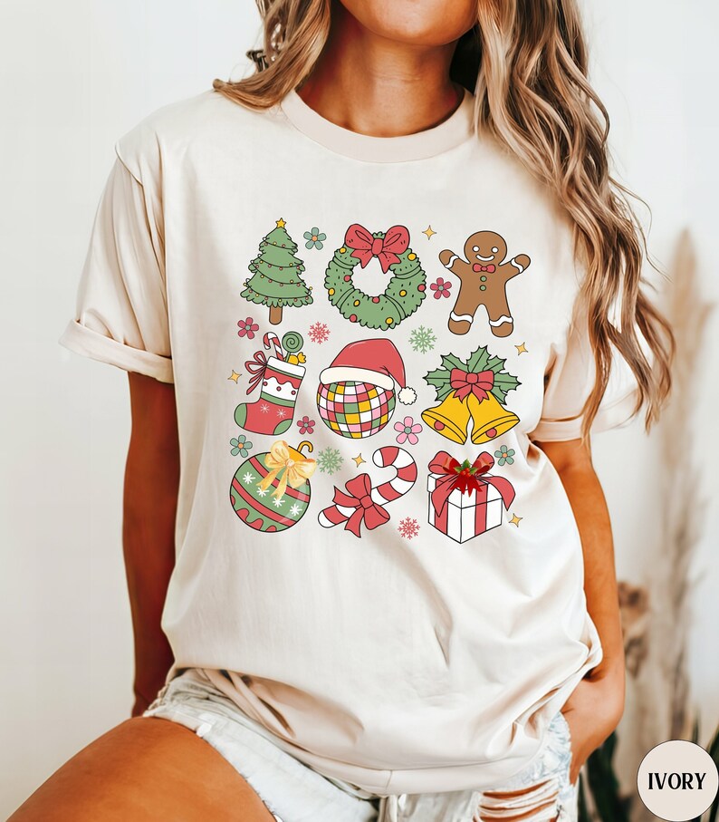 A retro Christmas Coquette graphic on a Comfort Colors shirt. The graphic has colors of red, green, gold and pink with a 3x3 pattern of Christmas elements. The shirt comes in 14 pretty colors.