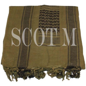 Puede incluir: Un shemagh, un pañuelo tradicional árabe, con estampado verde y negro, con flecos en los bordes. El shemagh está doblado y tiene la palabra "SCOTM" impresa.